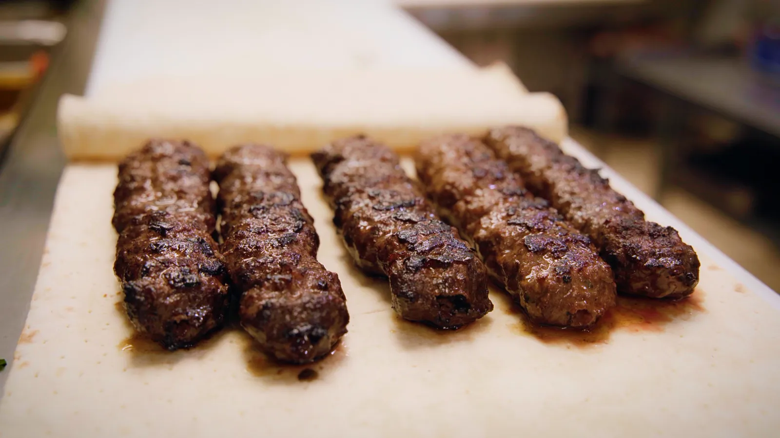 Five hand-shaped Adana kebabs resting on lavash at Aladdin Grill in Santa Rosa