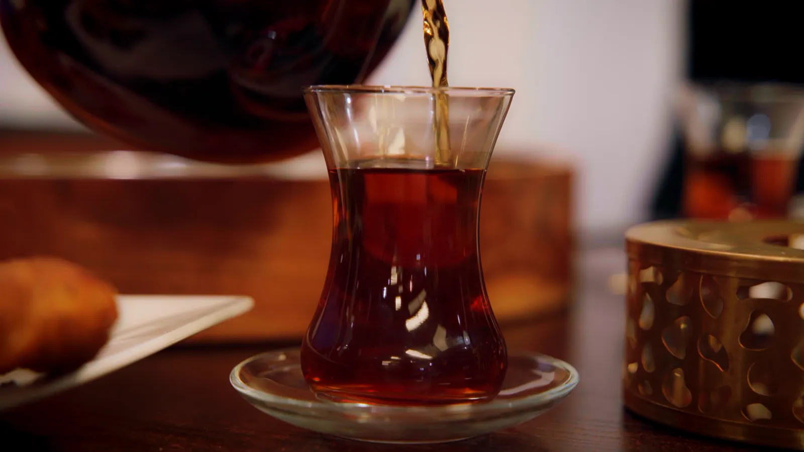 Turkish tea being poured into a tulip-shaped glass
