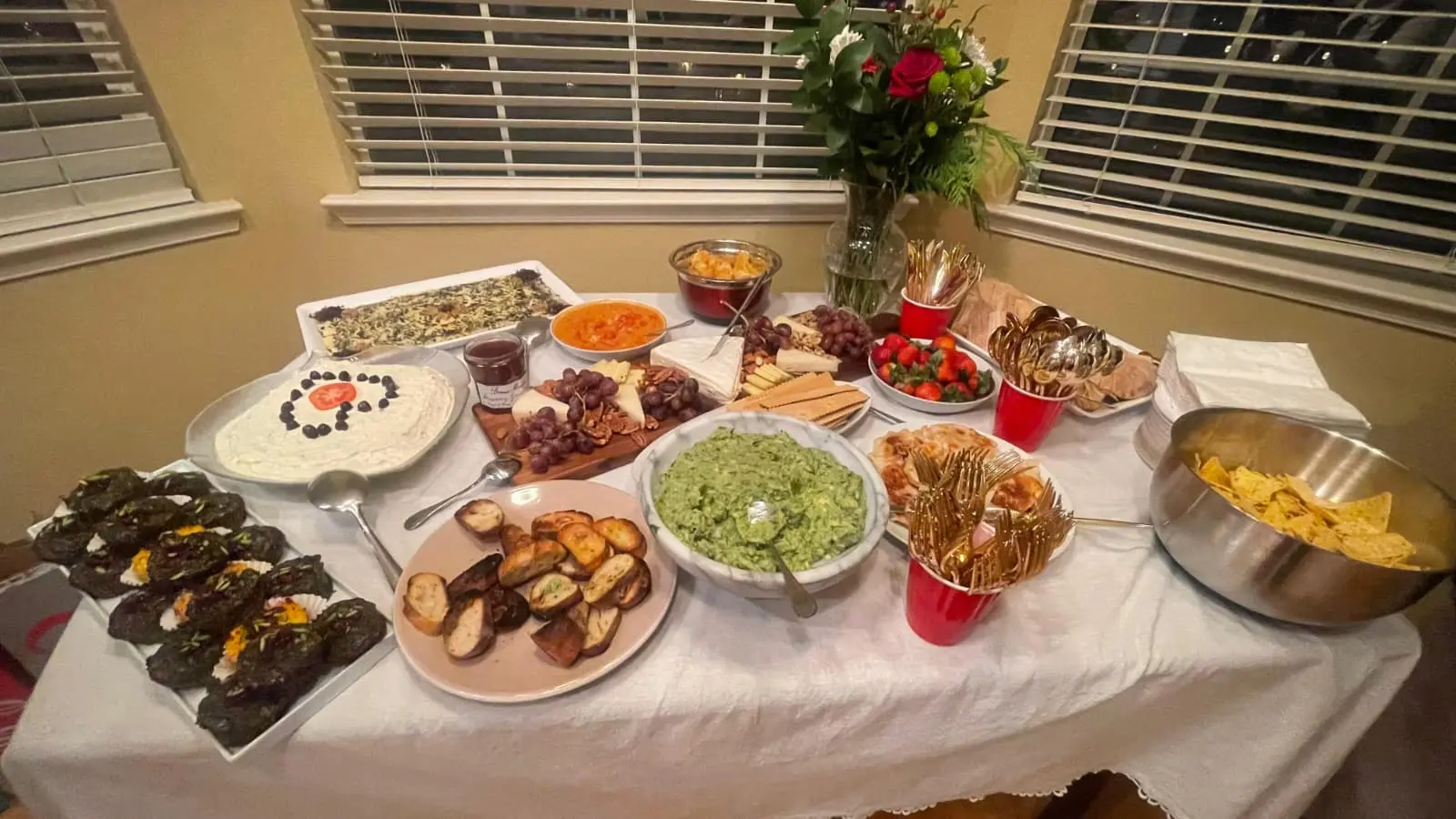 A Persian catering table arranged with rice, kabobs, dips and shared dishes