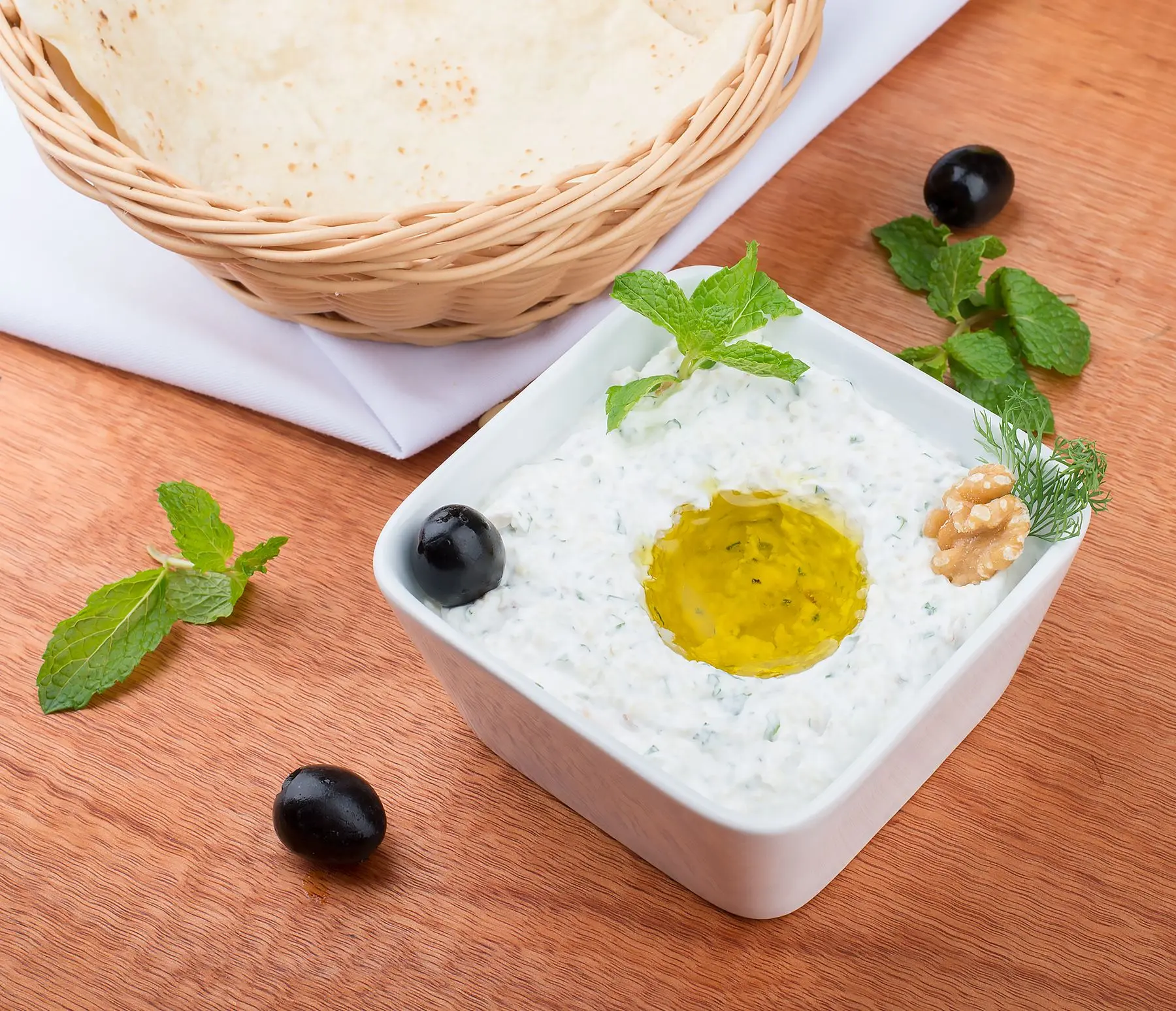 Tzatziki with cucumber, herbs and olive oil beside warm flatbread