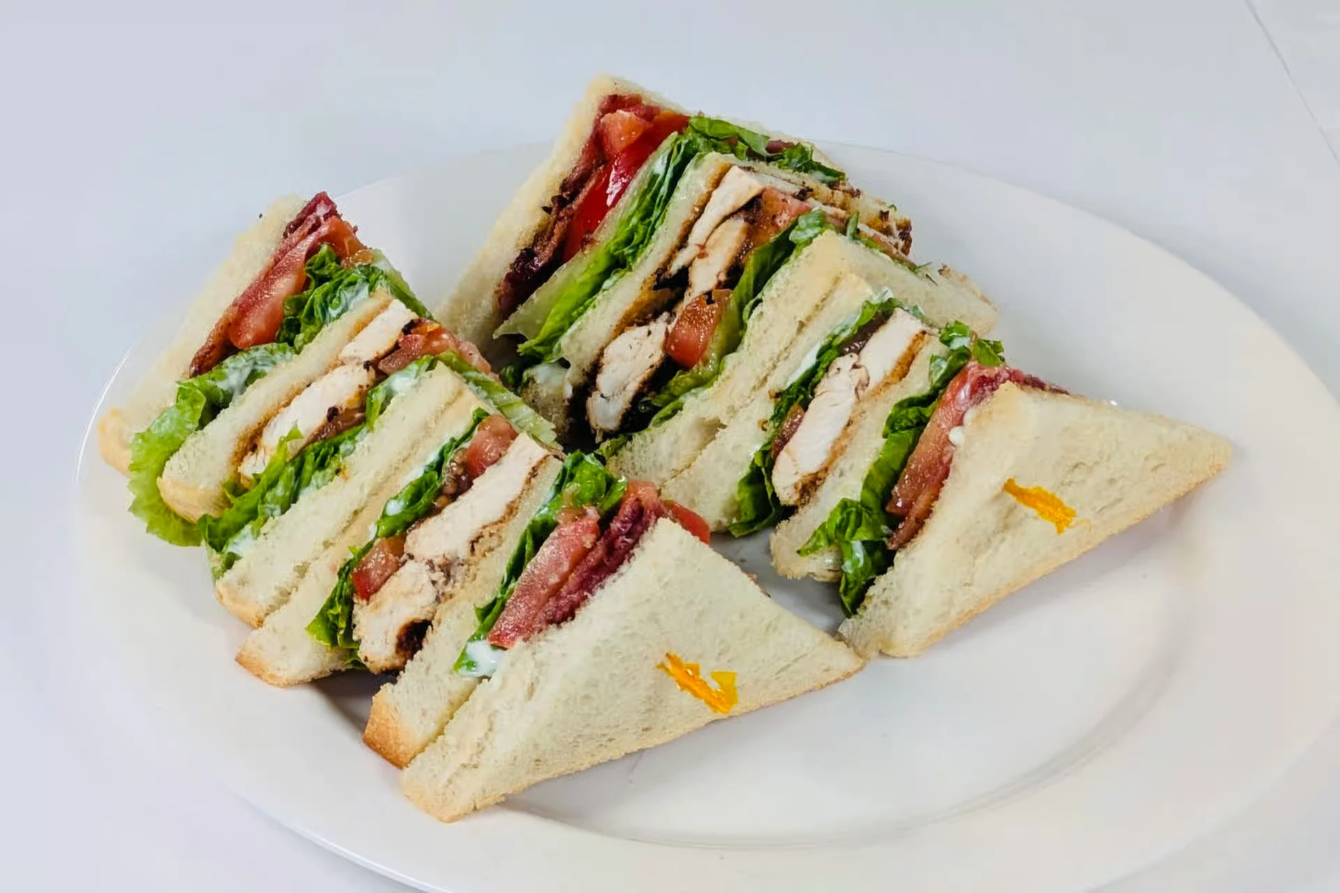 A grilled chicken club sandwich cut into quarters at D’s Diner