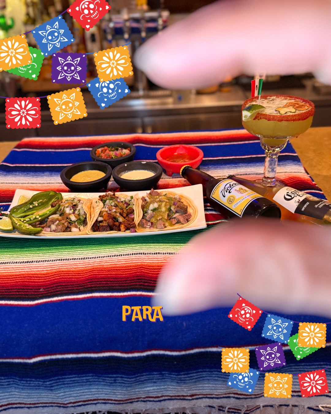 A margarita beside street tacos and salsas at Mi Pueblo